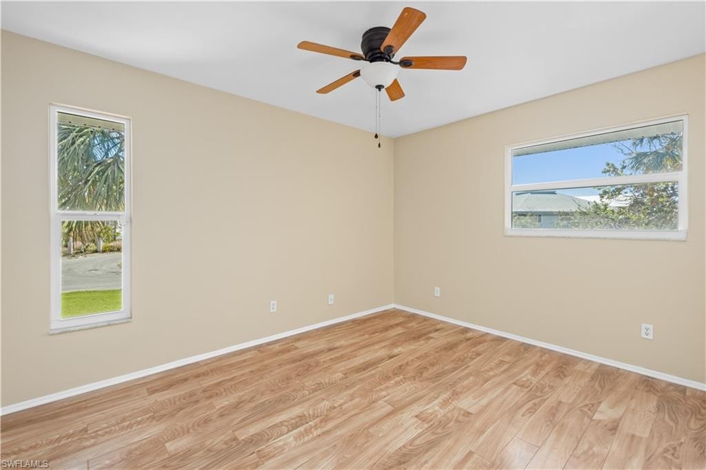 Spare room with light wood finished floors and a ceiling fan