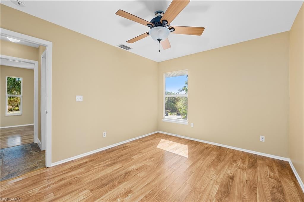 Spare room with light wood finished floors and a ceiling fan
