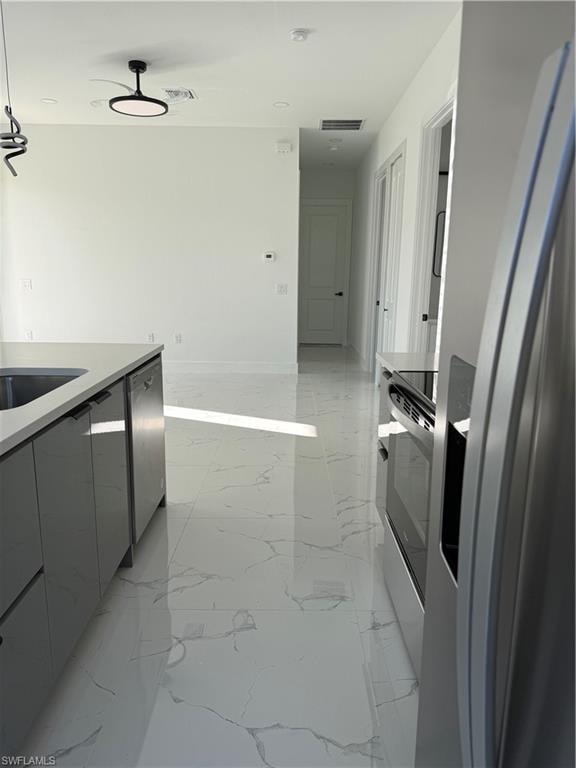 Kitchen with fridge, modern cabinets, stove, light stone counters, and light marble finish flooring