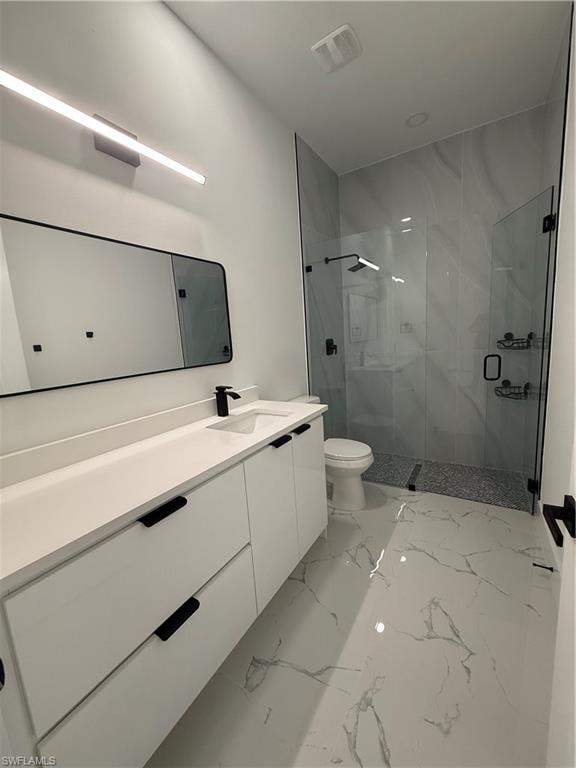 Bathroom featuring a marble finish shower, vanity, and light marble finish flooring
