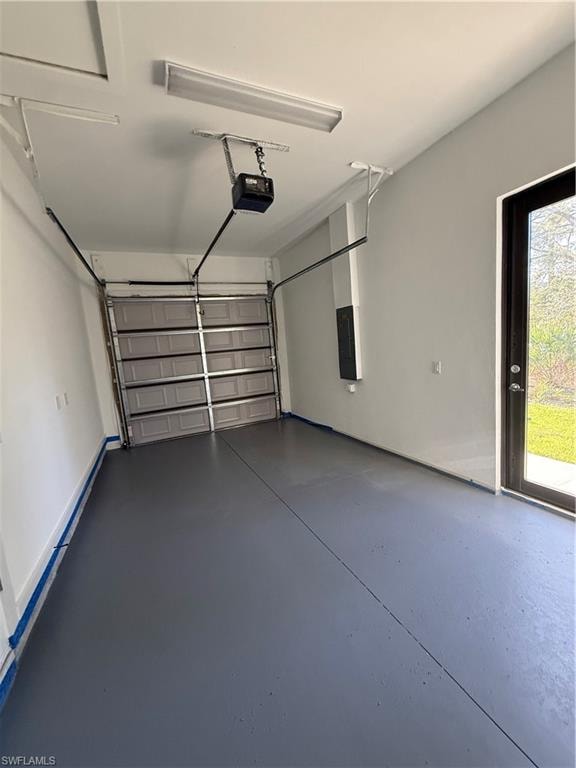 Garage featuring a garage door opener and electric panel