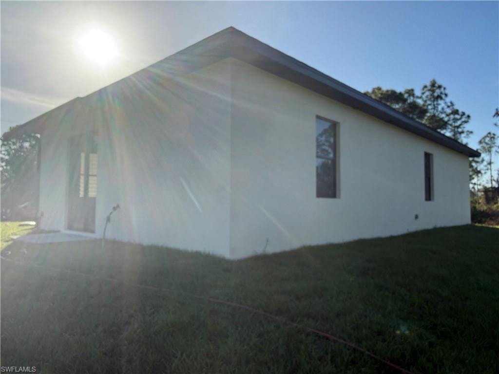 View of side of home featuring a lawn