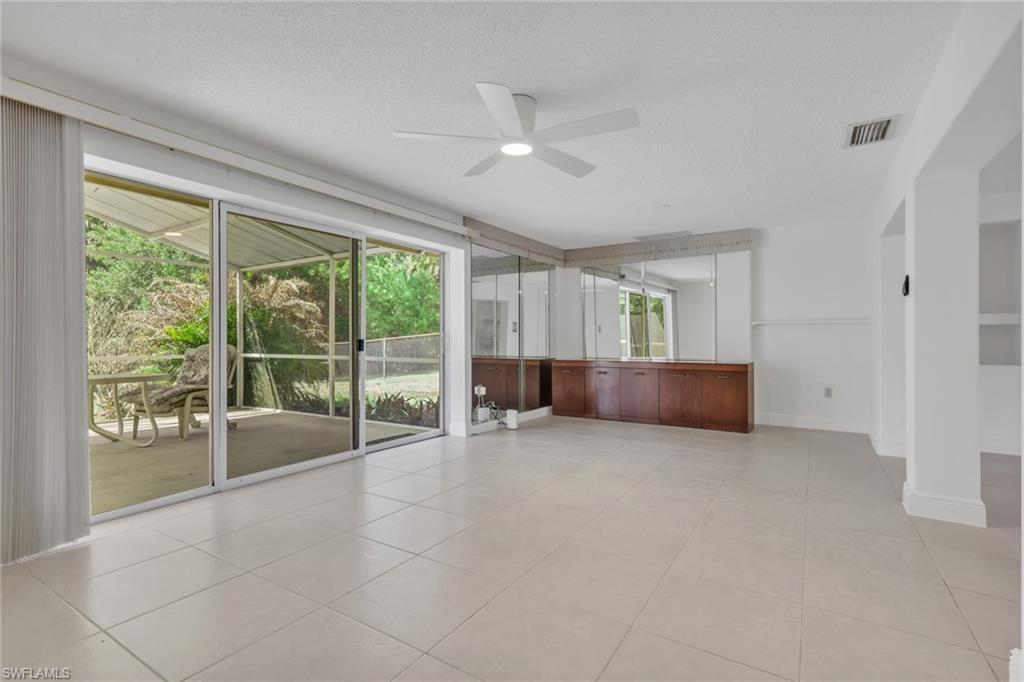 Unfurnished room featuring ceiling fan, light tile patterned flooring, and a textured ceiling