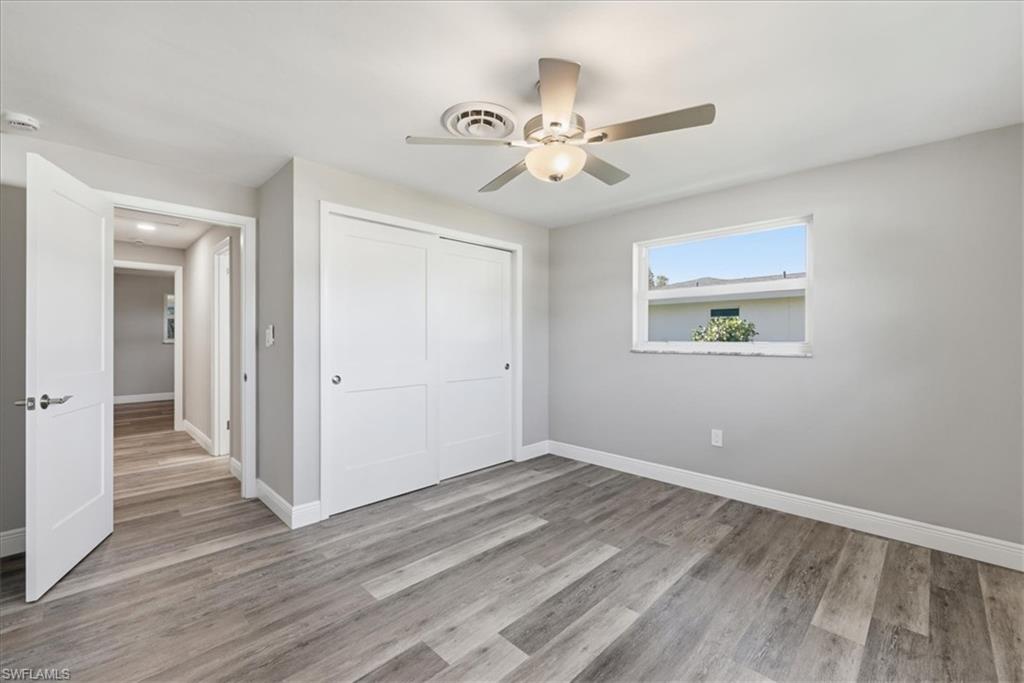 Unfurnished bedroom featuring light wood-type flooring, a closet, and a ceiling fan