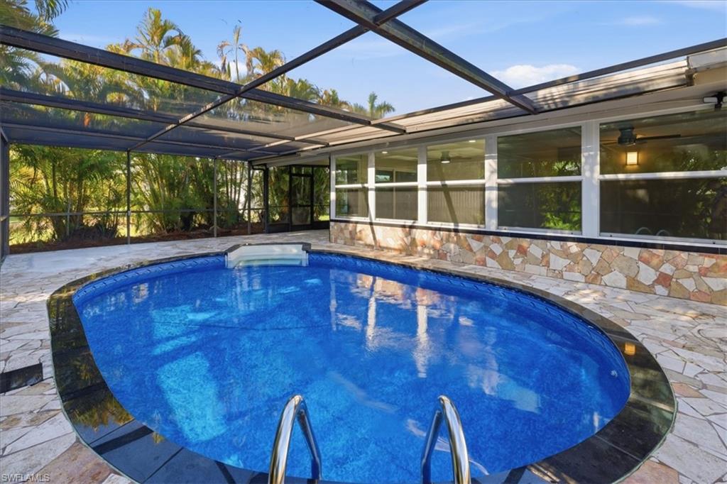 old Outdoor pool with a sunroom, glass enclosure, and a patio
