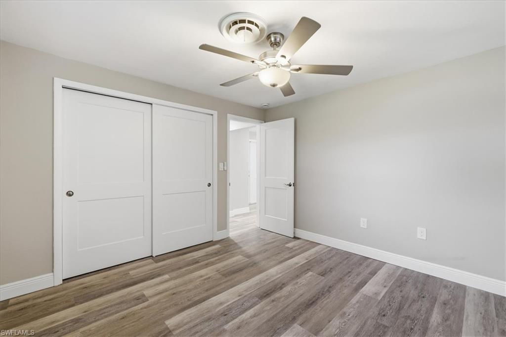 Unfurnished bedroom with a closet, light wood-style floors, and ceiling fan