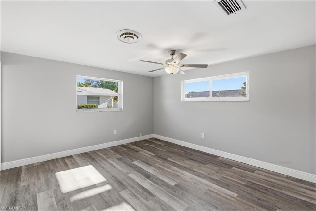 Master bedroom with light wood-style floors, a ceiling fan, and plenty of natural light