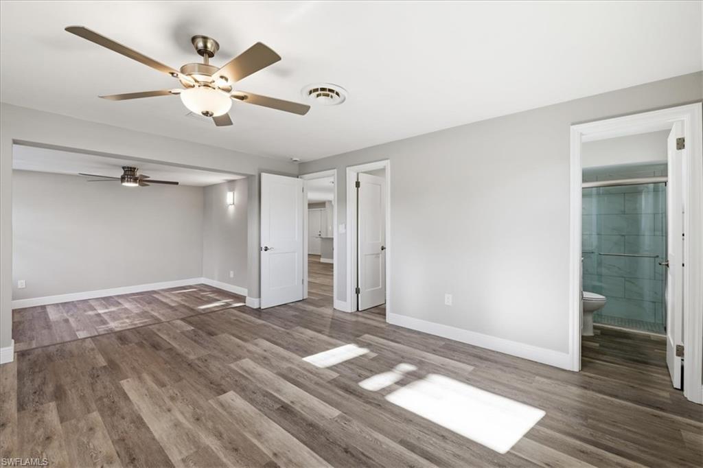Master  bedroom featuring dark wood finished floors, ceiling fan, and connected bathroom