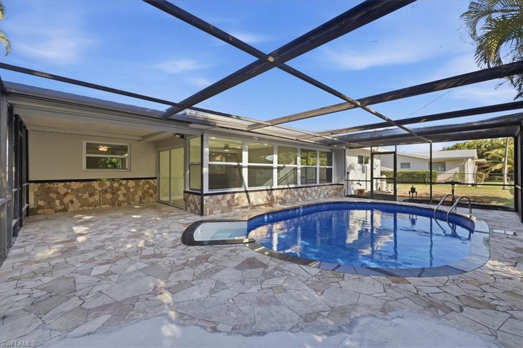 old Outdoor pool with a sunroom, glass enclosure, and a patio area