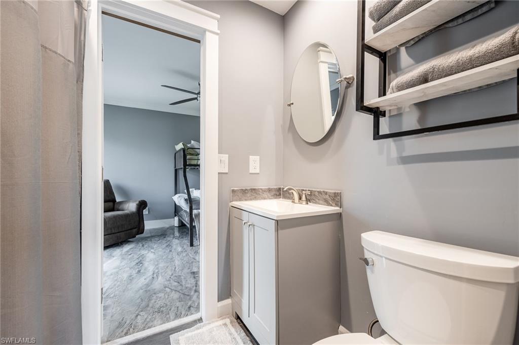 Half bath featuring vanity, a ceiling fan, and ensuite bath