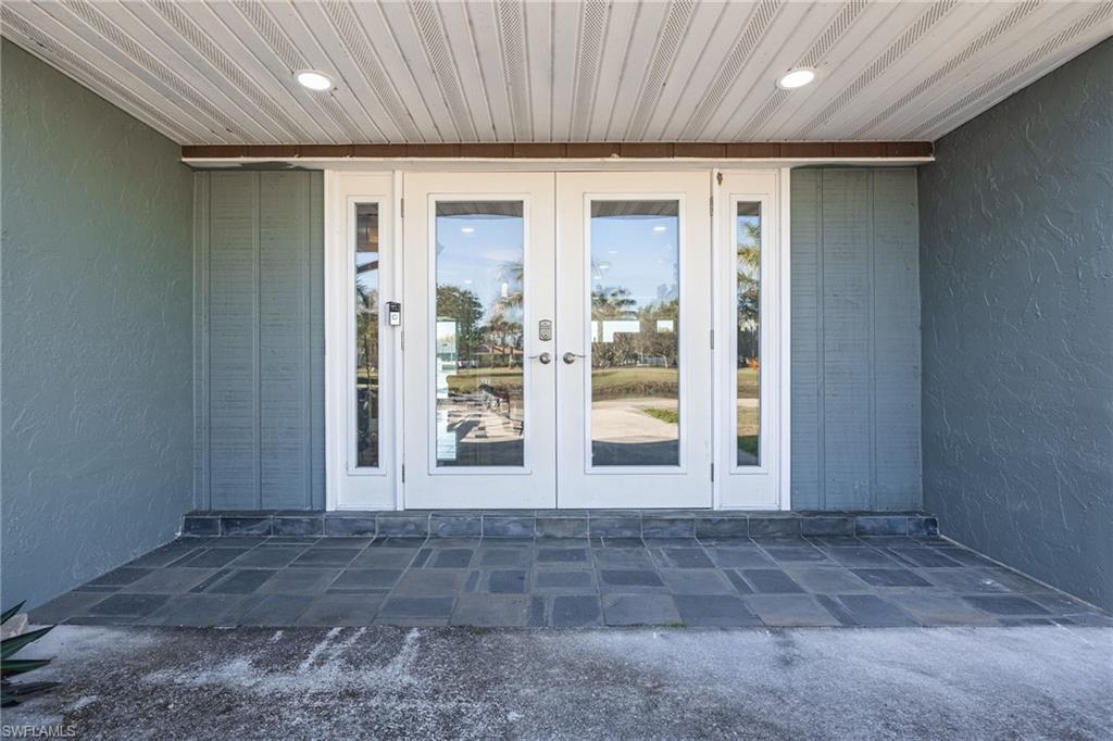 View of exterior entry with french doors, a patio, and stucco siding