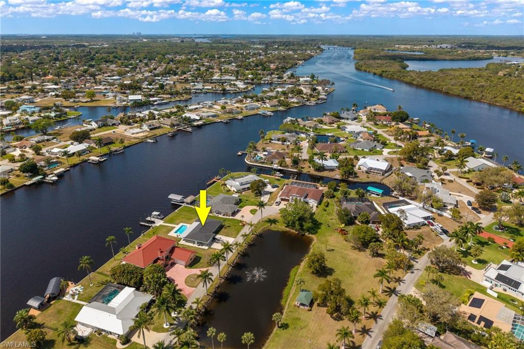 Aerial view of property and surrounding area featuring nearby suburban area and a nearby body of water
