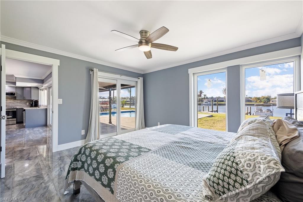 Bedroom featuring access to exterior, marble tiled flooring, ceiling fan, crown molding, and a water view