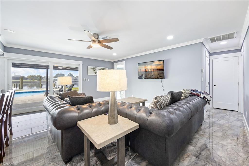 Living area featuring ceiling fan, crown molding, recessed lighting, and marble tiled flooring