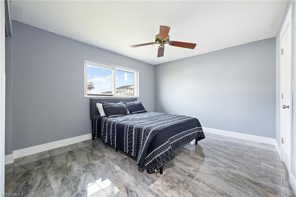 Bedroom with light marble finish flooring and ceiling fan