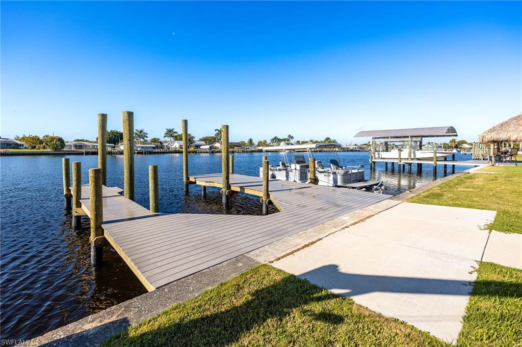 Dock area with a water view and a yard