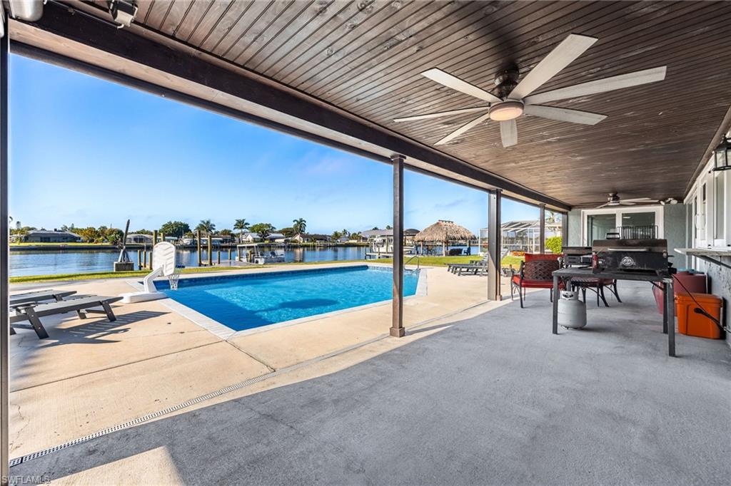 Outdoor pool with a patio, a residential view, and a dock
