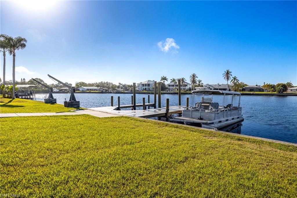 Dock featuring a lawn, a water view, and a residential view