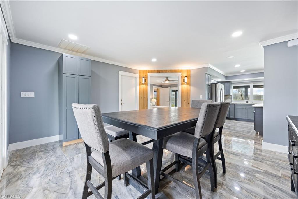 Dining area with crown molding and recessed lighting