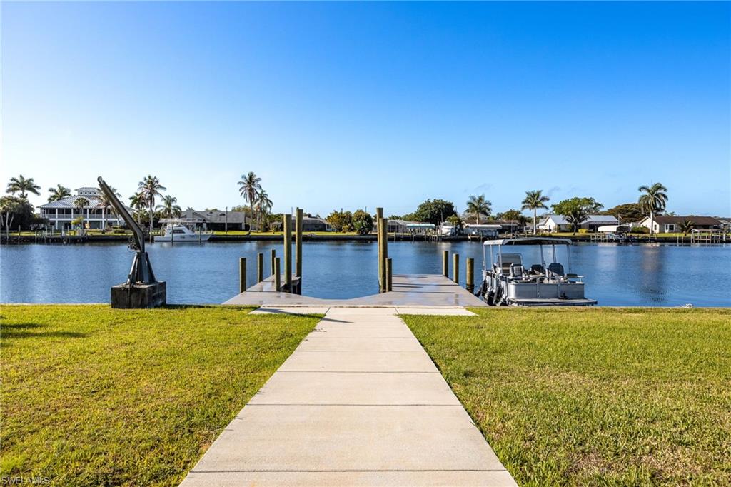 Dock featuring a lawn, a water view, and a residential view