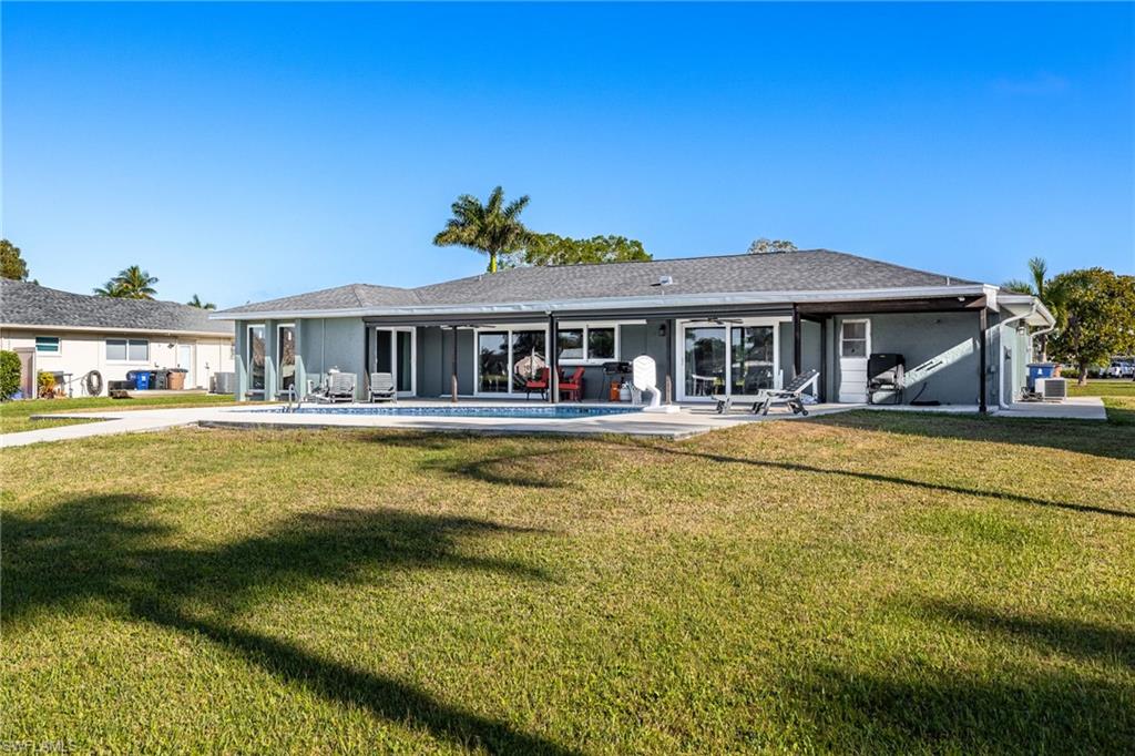 Rear view of property with a lawn and a patio