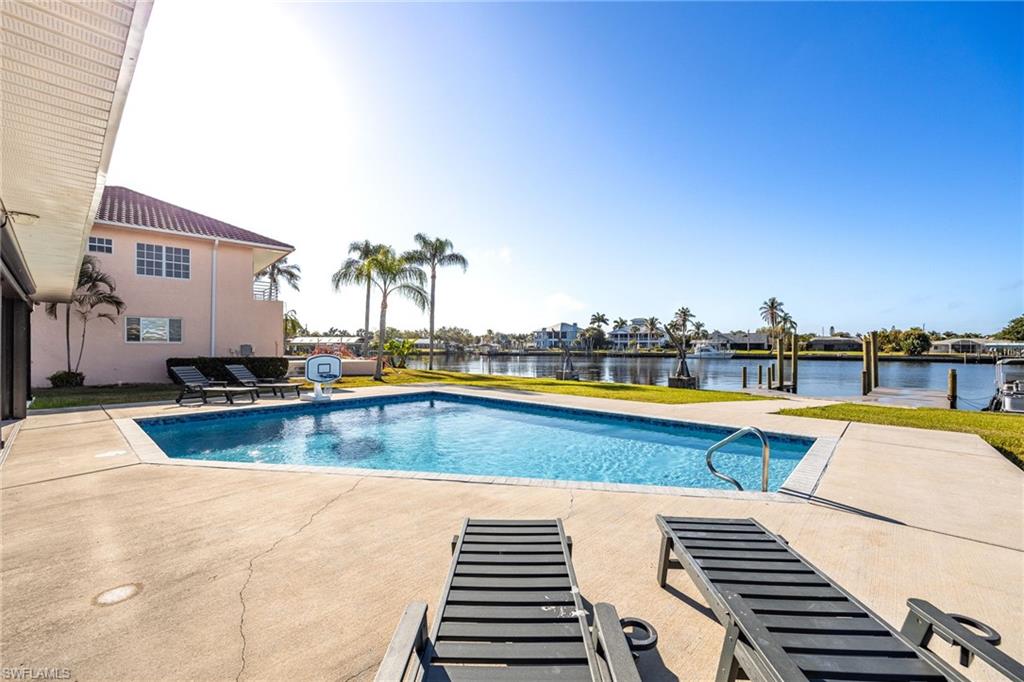 Outdoor pool featuring a patio and a water view