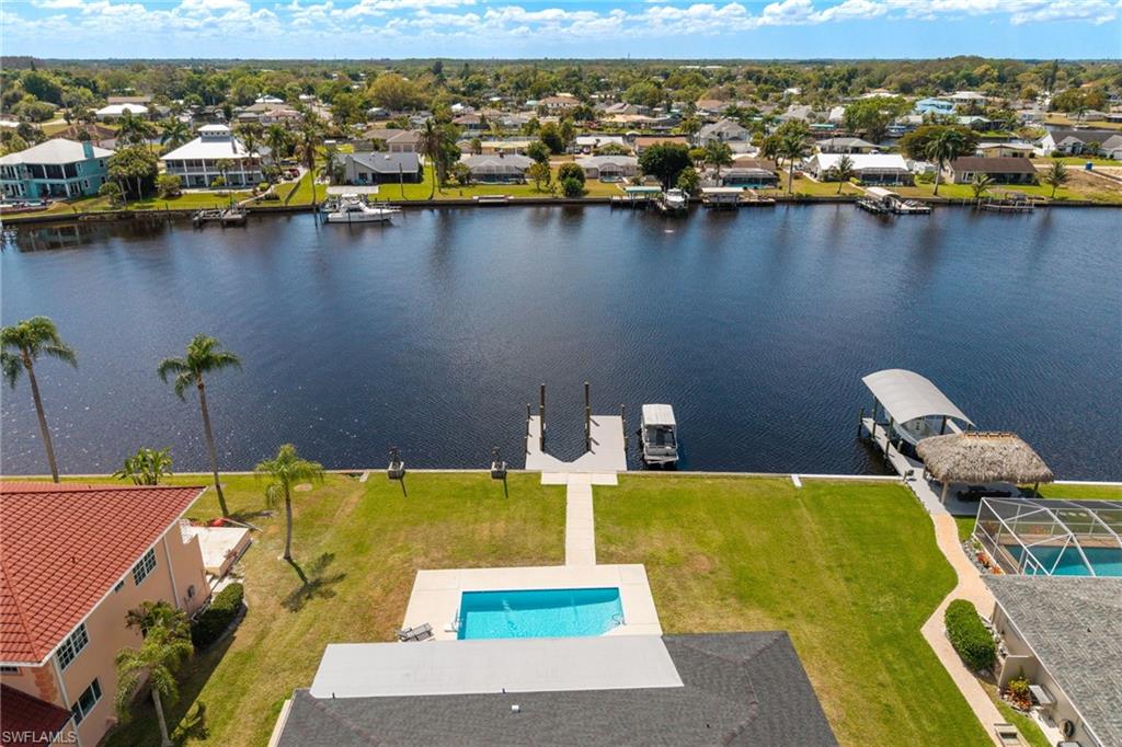 Aerial perspective of suburban area with a large body of water and a pool