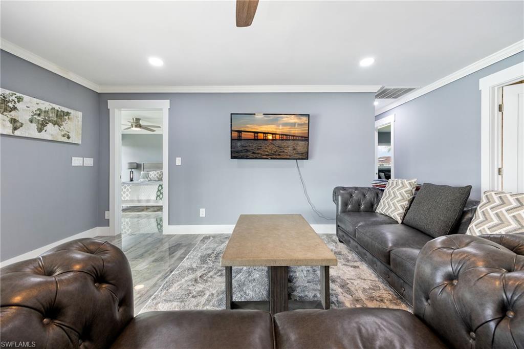 Living room featuring ceiling fan, ornamental molding, and recessed lighting