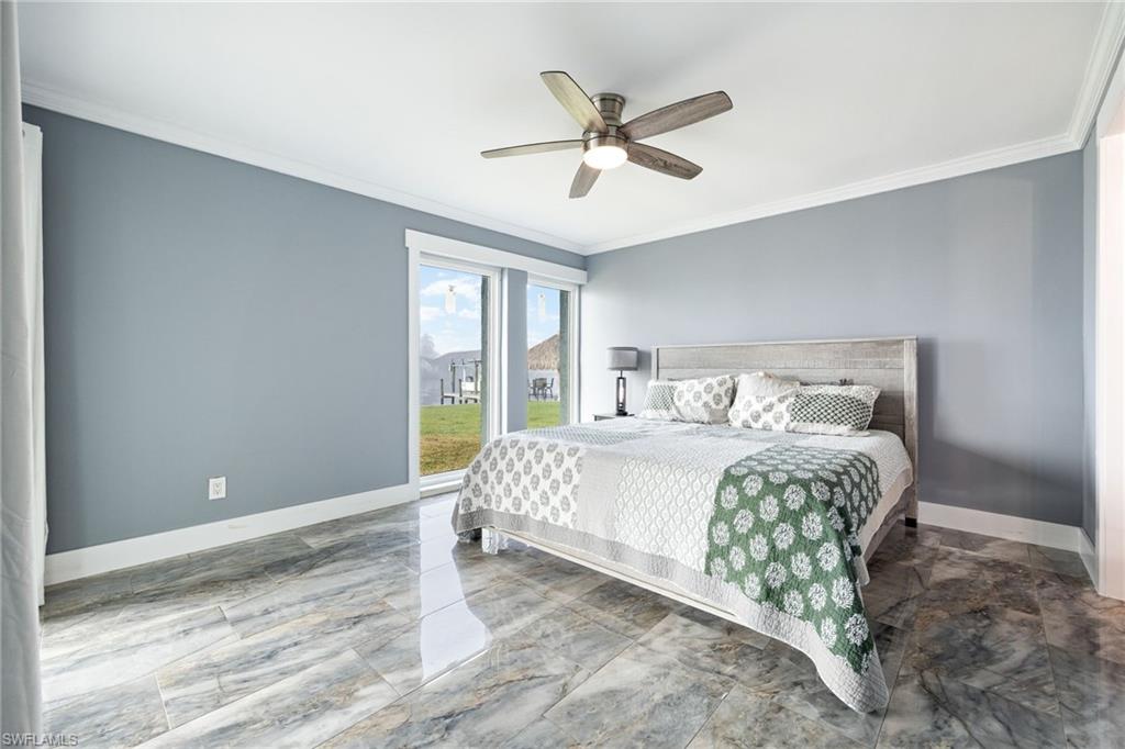 Bedroom with ornamental molding, light marble finish flooring, and a ceiling fan
