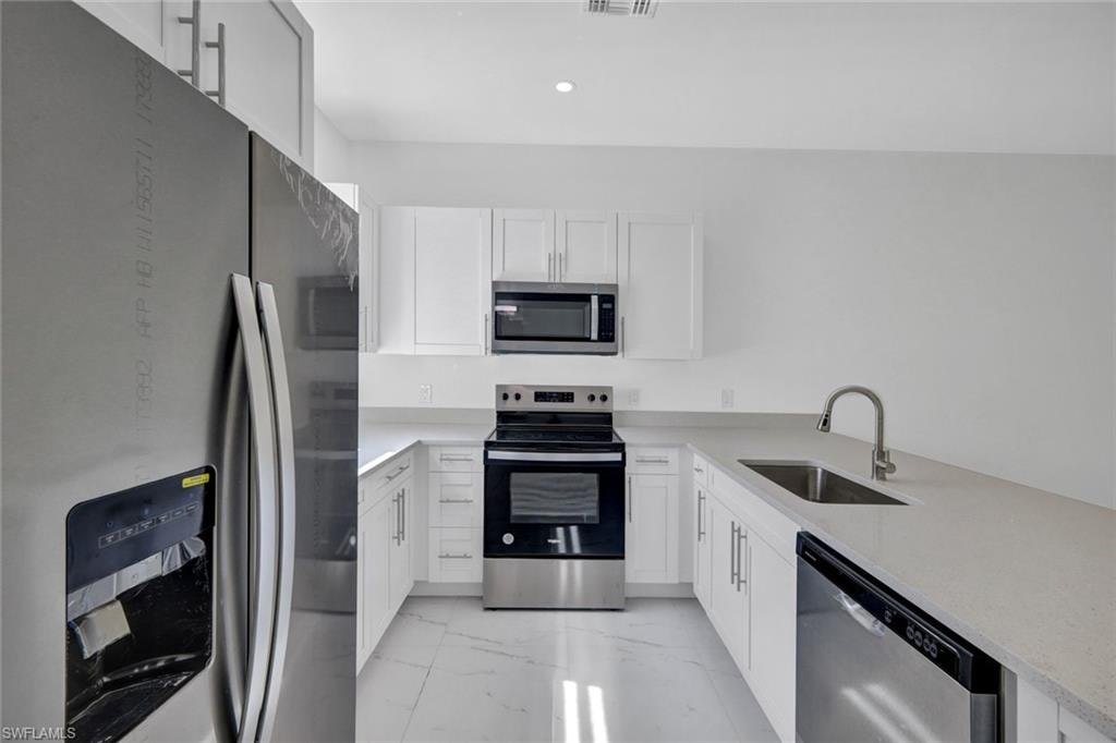 Kitchen with stainless steel appliances and white cabinets