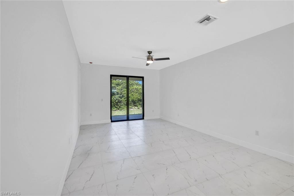 Unfurnished room featuring light marble finish flooring and a ceiling fan