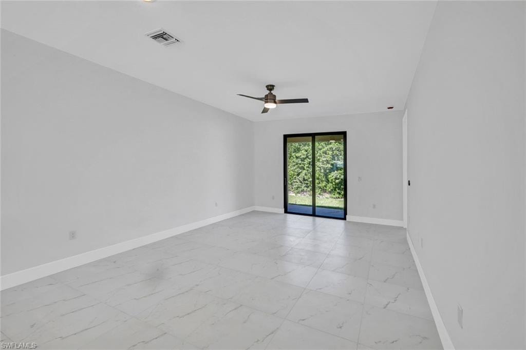 Spare room featuring light marble finish floors and a ceiling fan