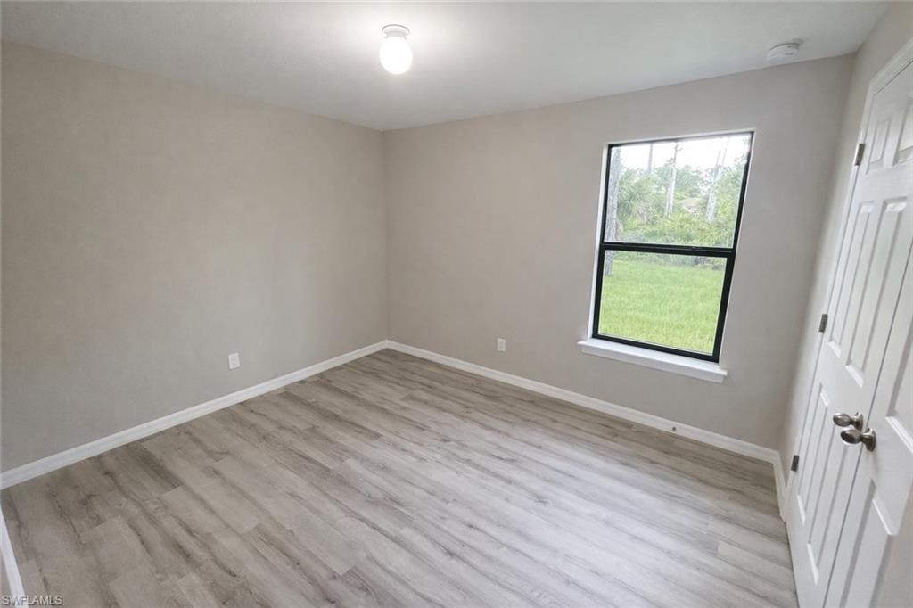 Unfurnished bedroom with light wood-style flooring and baseboards