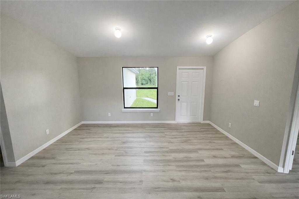 Spare room with light wood-style floors and baseboards