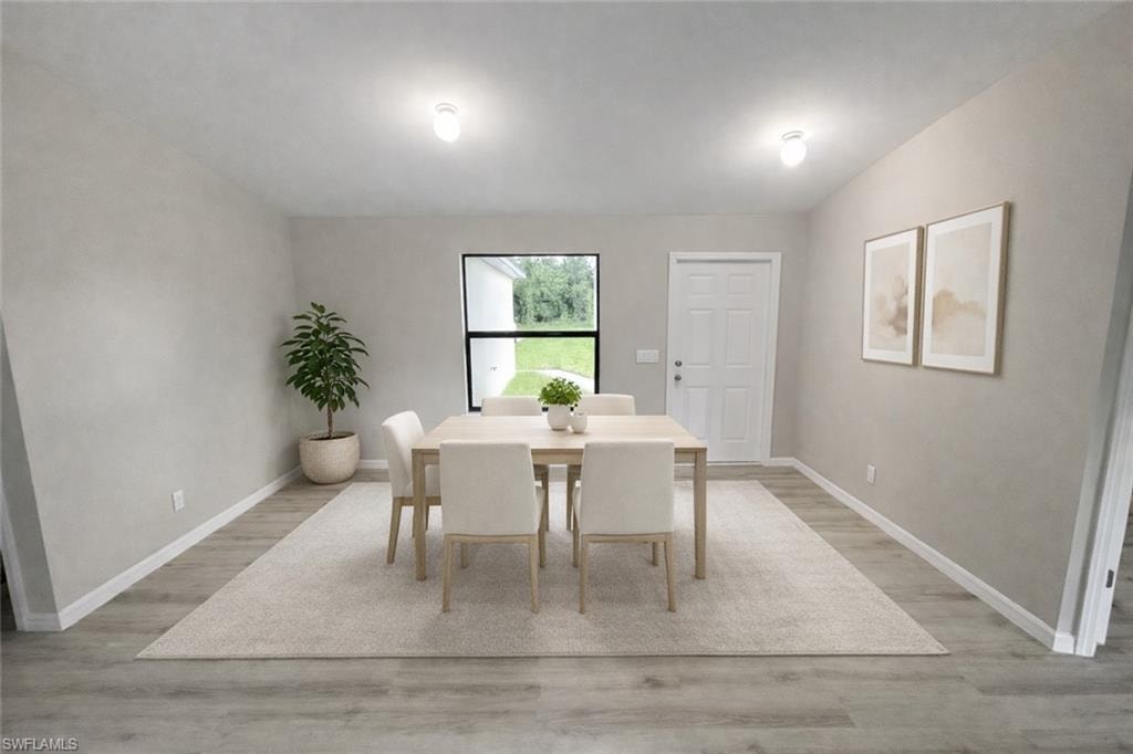 Dining area featuring light wood-type flooring and vaulted ceiling