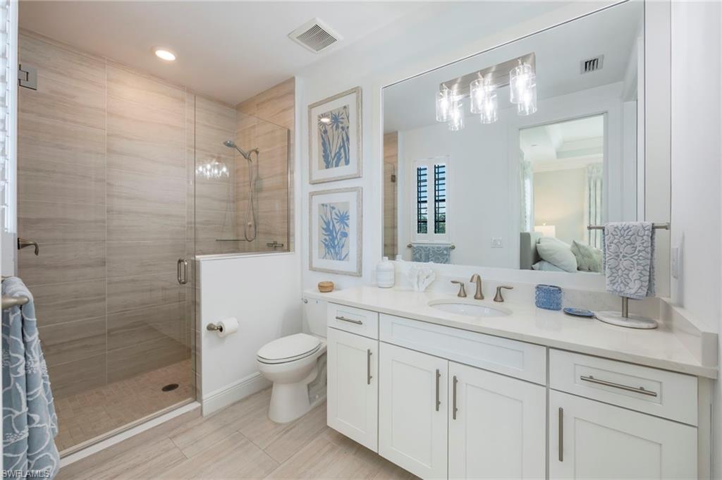 Ensuite bathroom featuring a shower stall and vanity