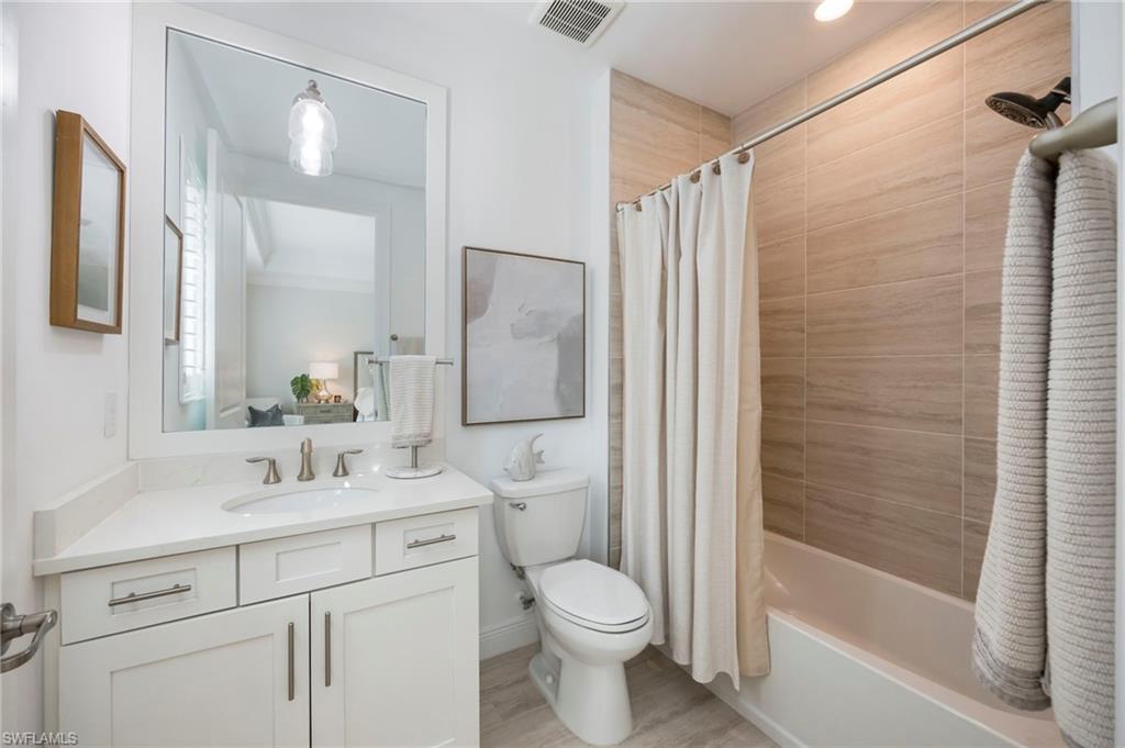 Full bathroom with vanity, shower / bath combination with curtain, and light wood finished floors