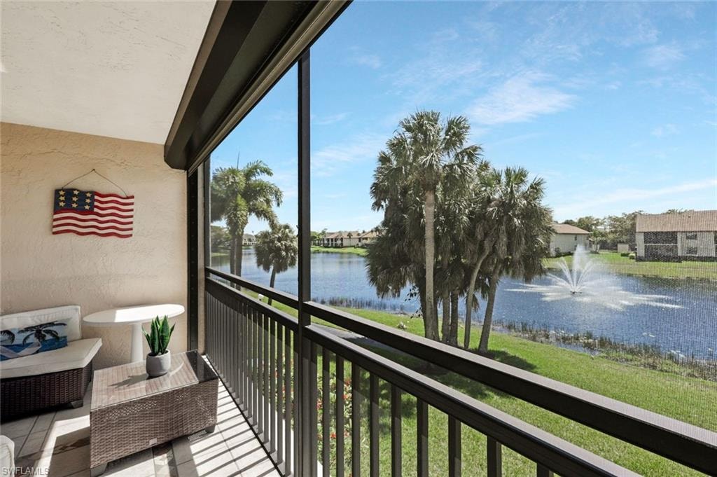 Balcony featuring a sunroom and a water view