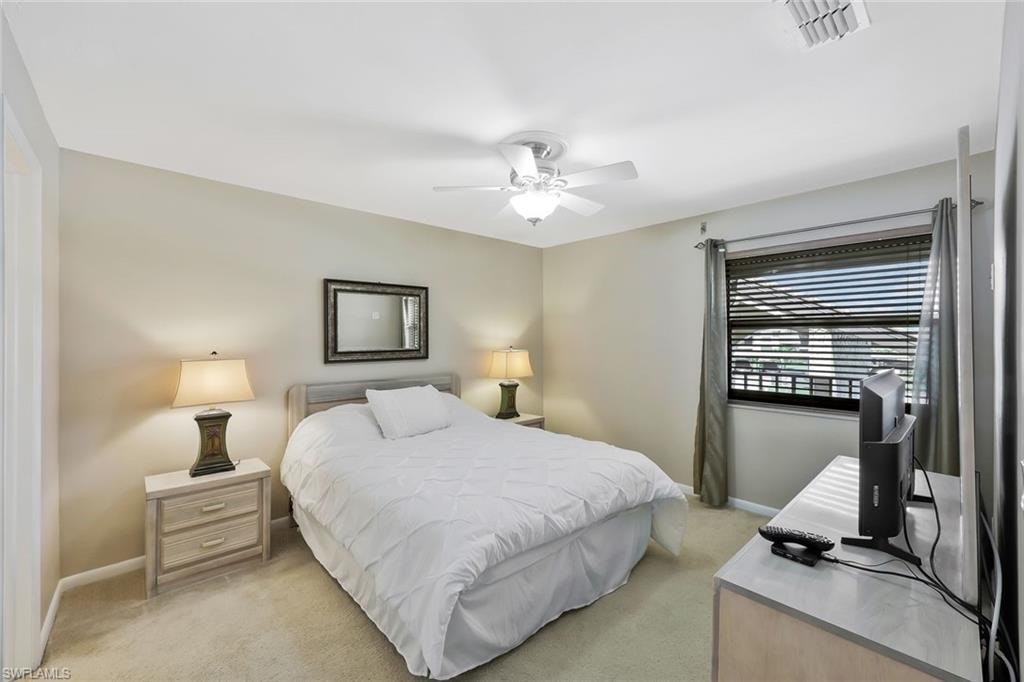 Bedroom with light colored carpet and a ceiling fan