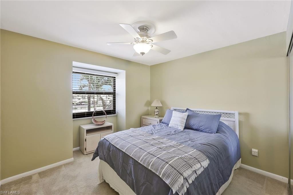 Carpeted bedroom featuring baseboards and a ceiling fan