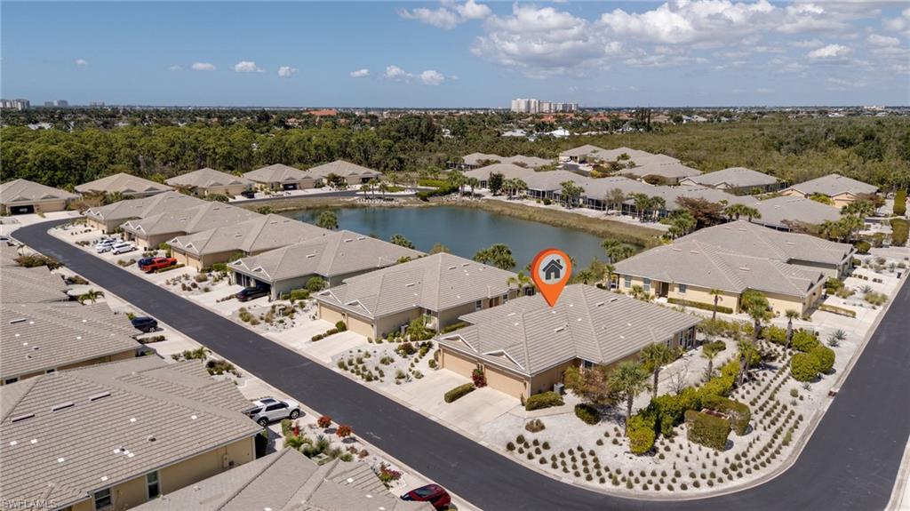 Aerial perspective of suburban area with a large body of water and a tree filled landscape