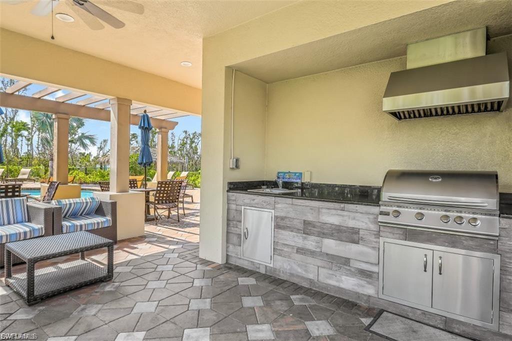 View of patio / terrace with a ceiling fan, exterior kitchen, a pergola, and an outdoor lounge area with bar