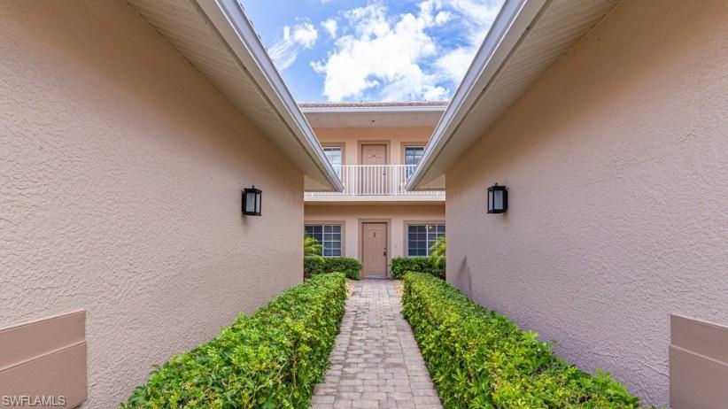 View of exterior entry with stucco siding and a balcony