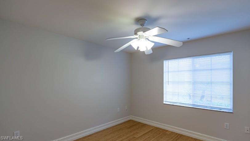 Empty room featuring a ceiling fan, baseboards, and light wood finished floors