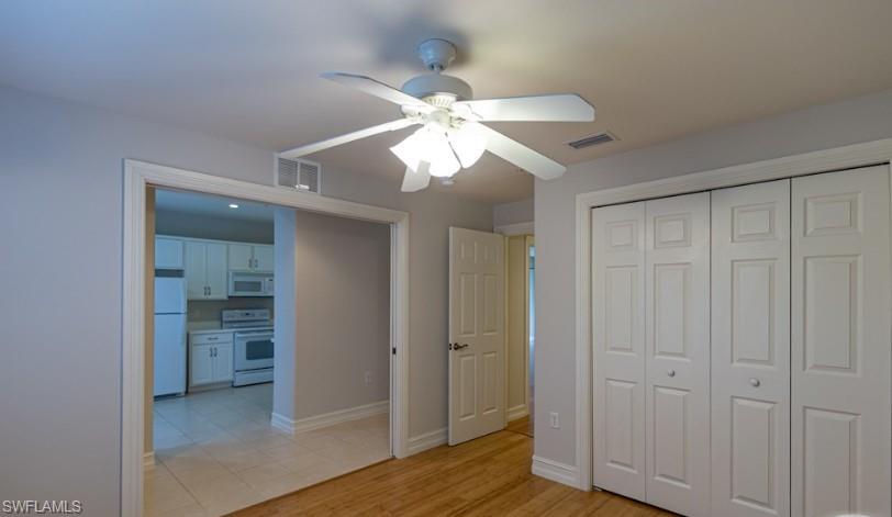 Unfurnished bedroom featuring a closet, baseboards, visible vents, and freestanding refrigerator
