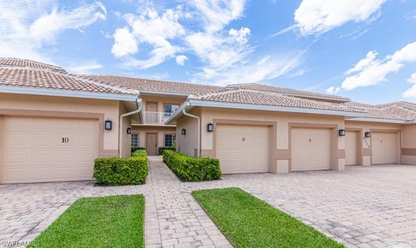 Multi unit property with stucco siding, decorative driveway, a balcony, and an attached garage