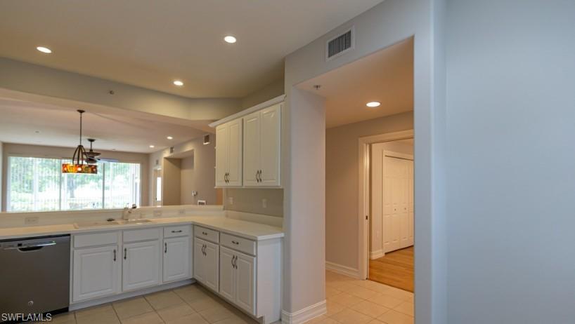 Kitchen featuring a sink, dishwasher, recessed lighting, and white cabinetry