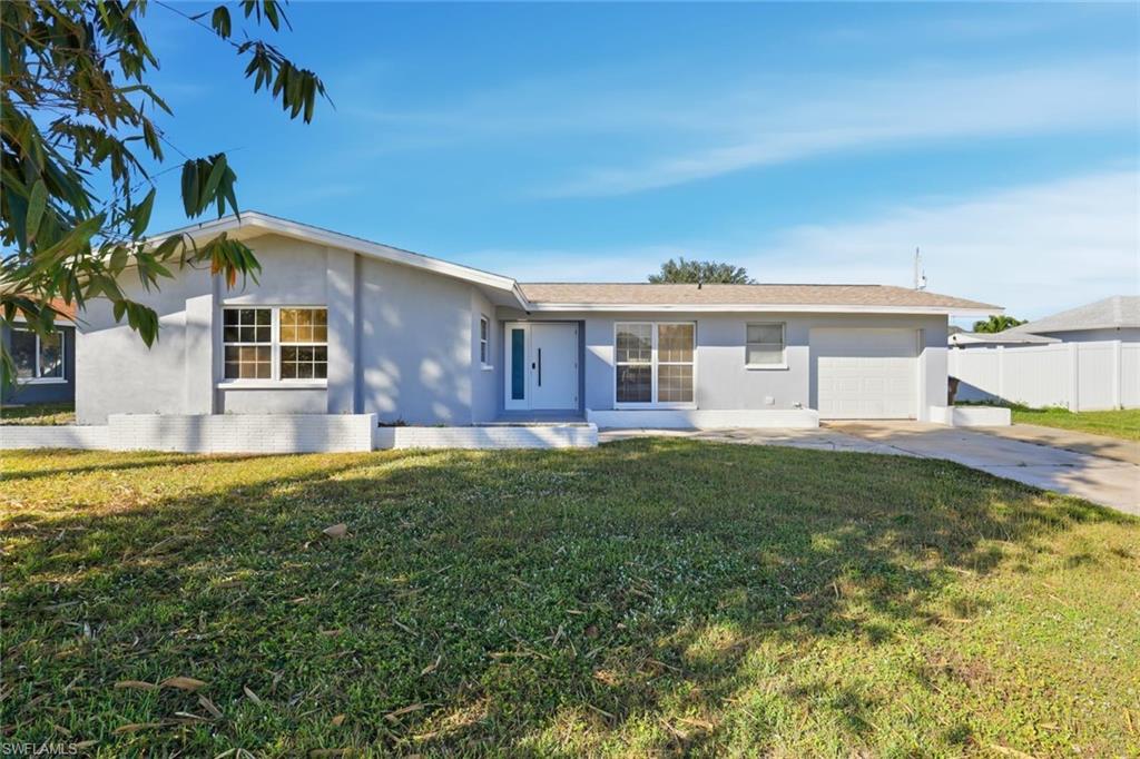 Single story home with stucco siding, a garage, and driveway