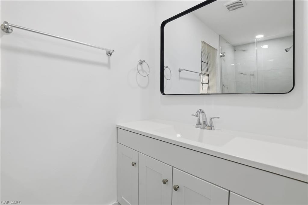 Bathroom with vanity, a shower stall, and recessed lighting