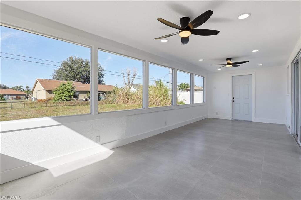 Unfurnished sunroom featuring concrete flooring and recessed lighting